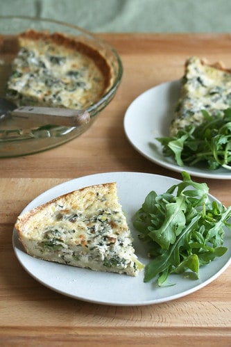 leek and fiddlehead quiche on a plate with salad