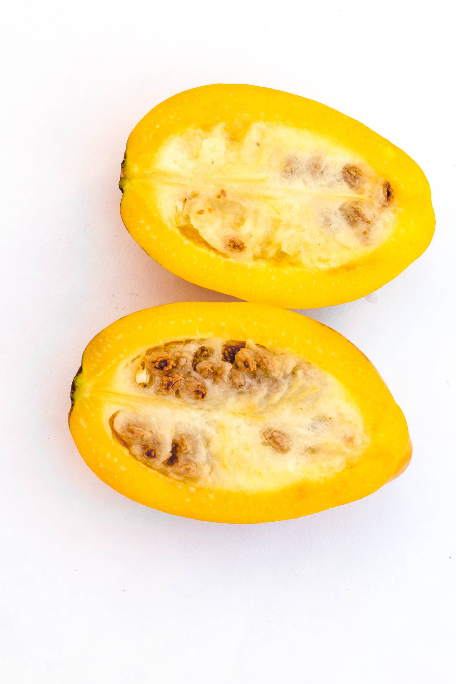 Fresh and tasty Arequipena papaya with seeds isolated on white, in Arequipa, Peru. Smaller than usual this papaya is called "Papaya Arequipea".