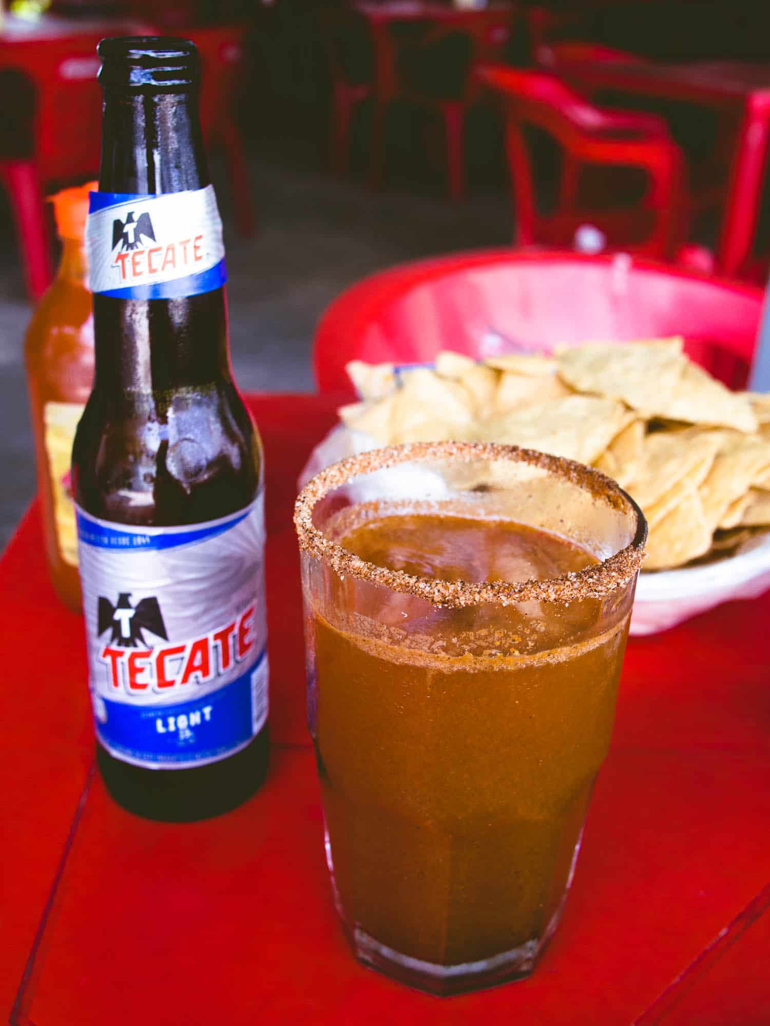 Mexican michelada drink on a table with tecate beer