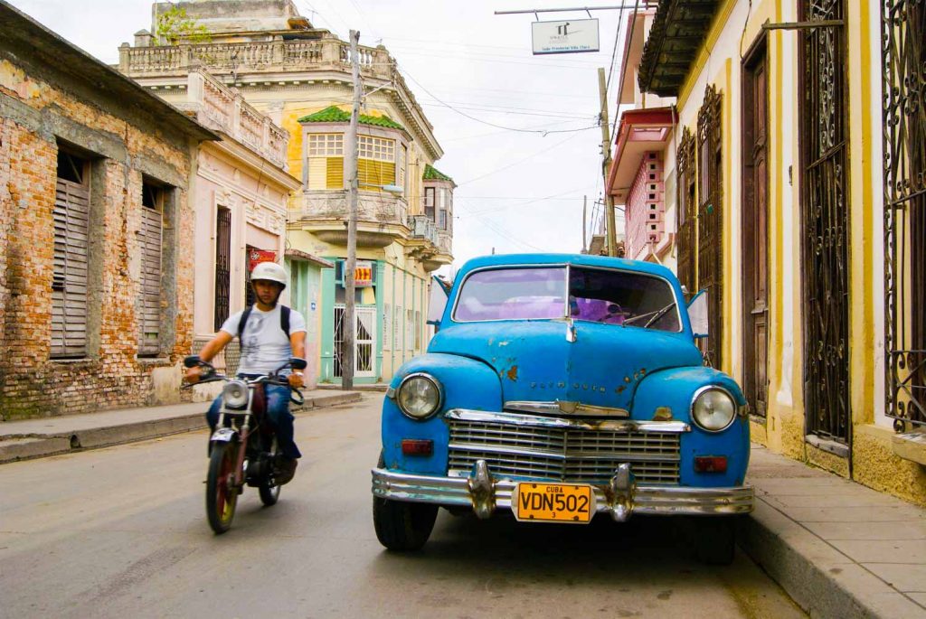 Santa Clara Cuba street with vintage car and motorcycle