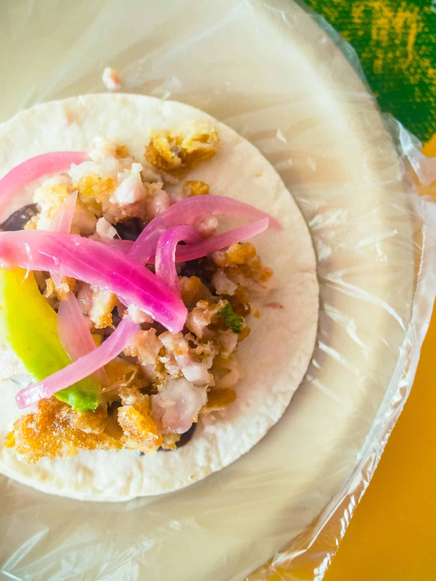 Tacos in Belize with pickled red onion and avocado