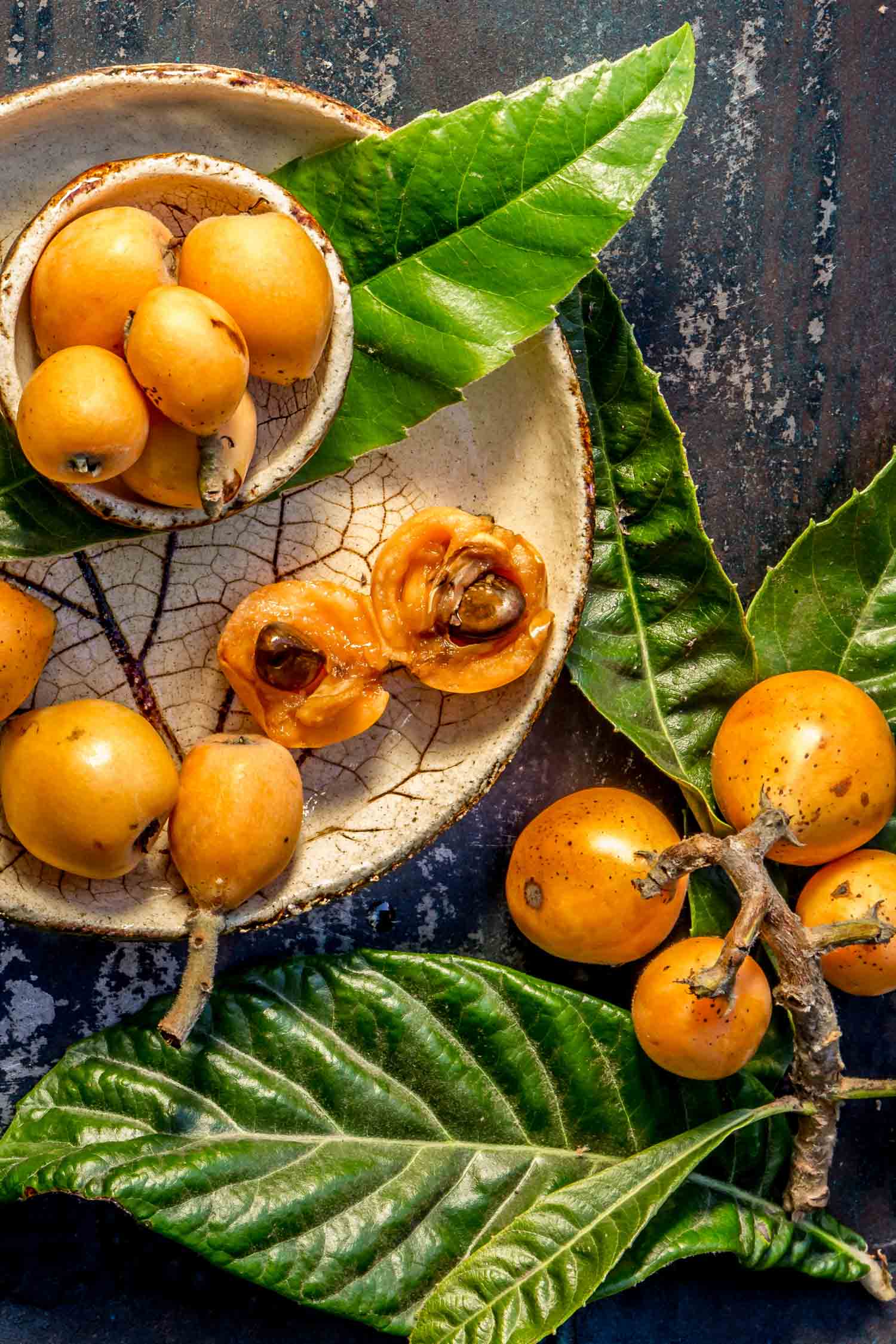 Hawaiian Loquat fruit. Nispero. Eriobotrya Japonica. Loquat with fresh leaves on metal background.