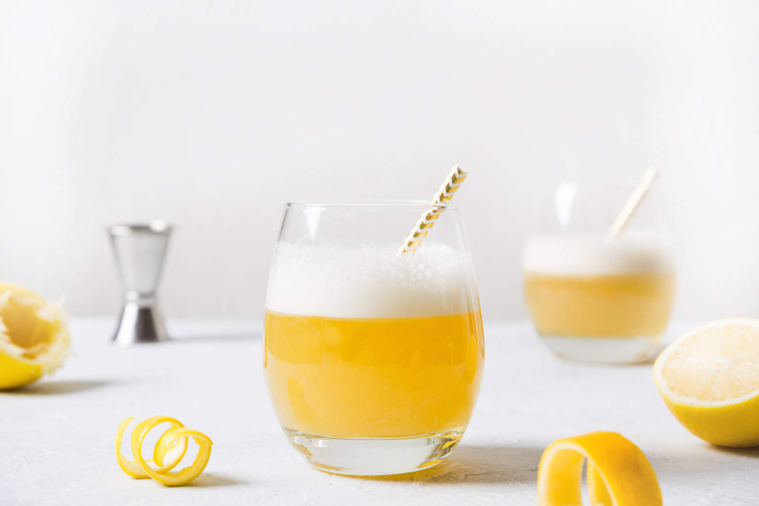 Boston sour cocktail - bourbon with lemon juice, sugar syrup and egg white in glass. Vertical orientation.