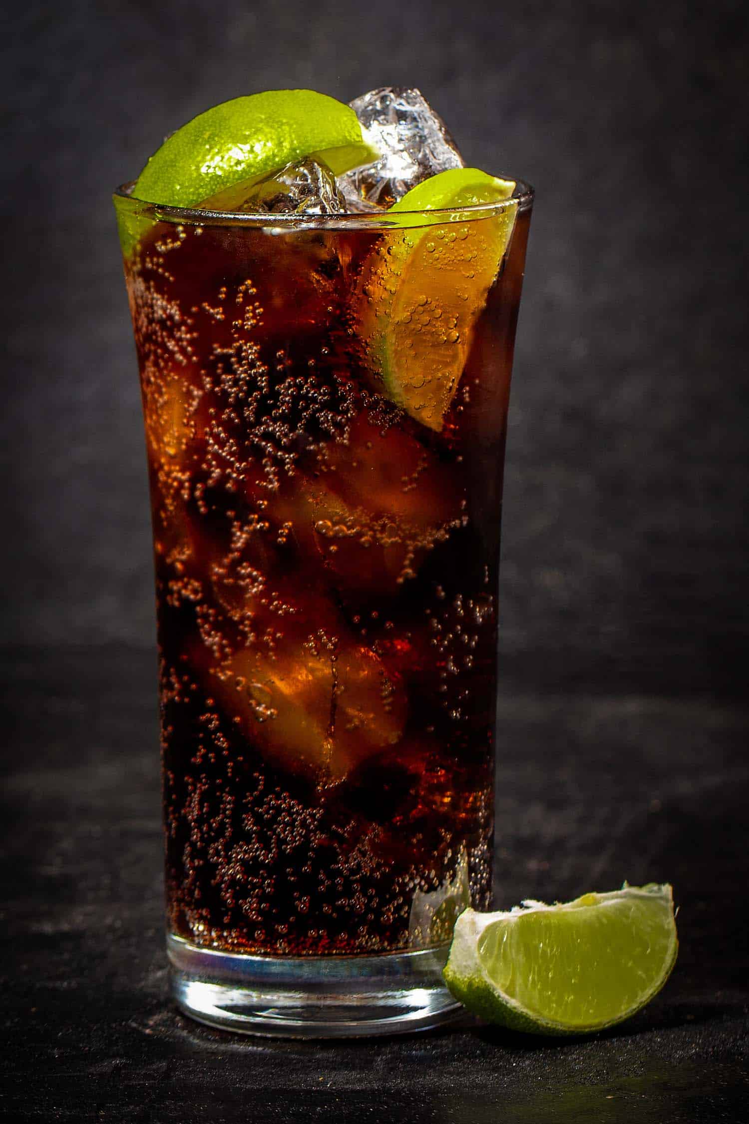 Charro negro cocktail with lime on a black background is one of the most popular cocktails around the world