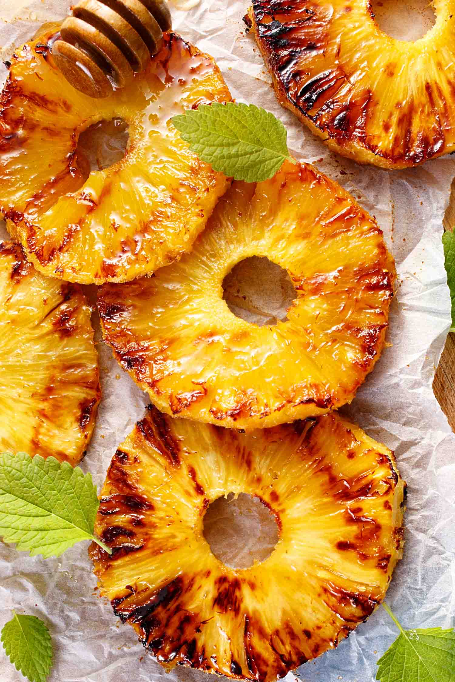 Classic fruit in Hawaii. Grilled pineapple slices with addition of honey on a blue table, top view