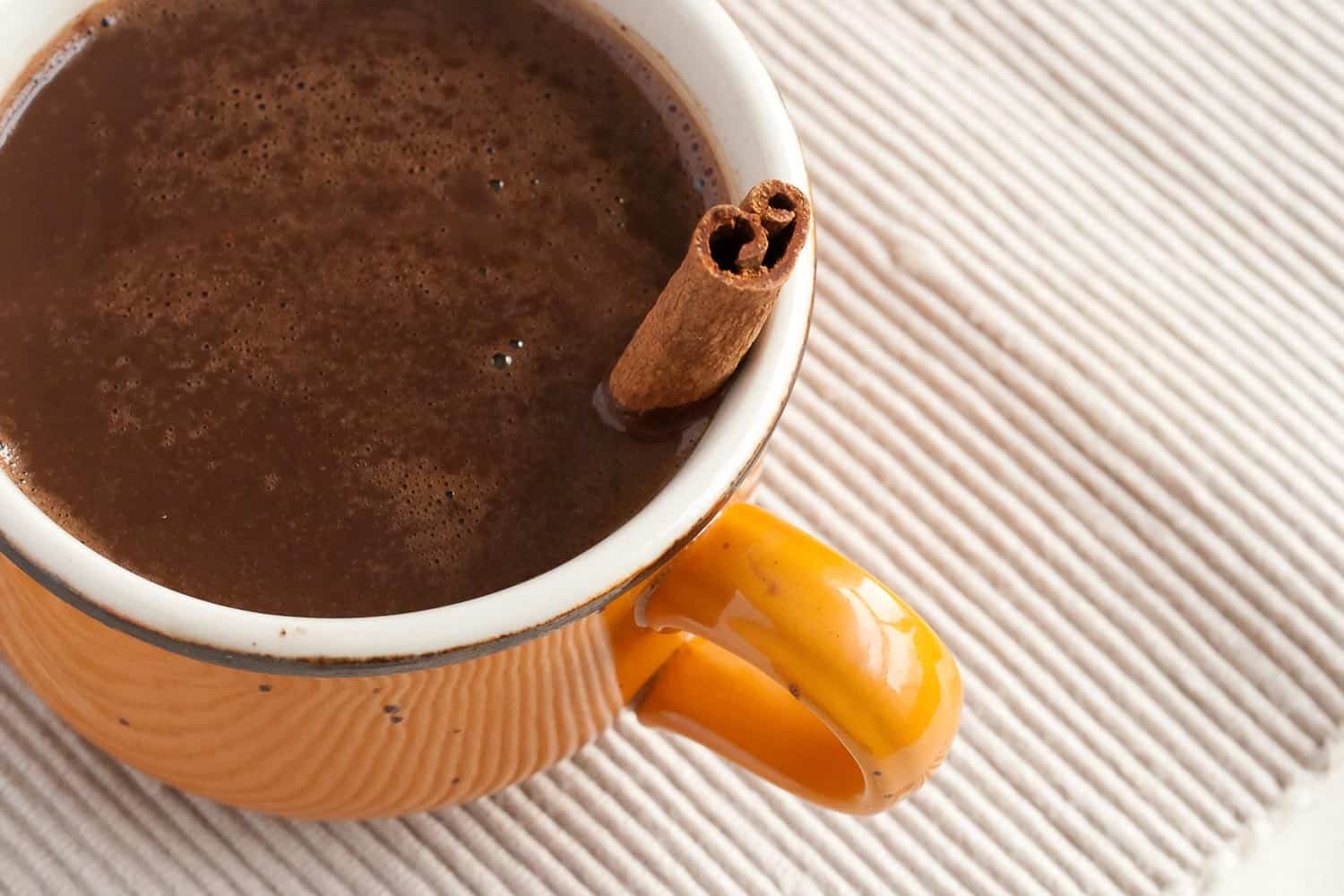 Champurrado drink in Mexico with cinnamon on the mug