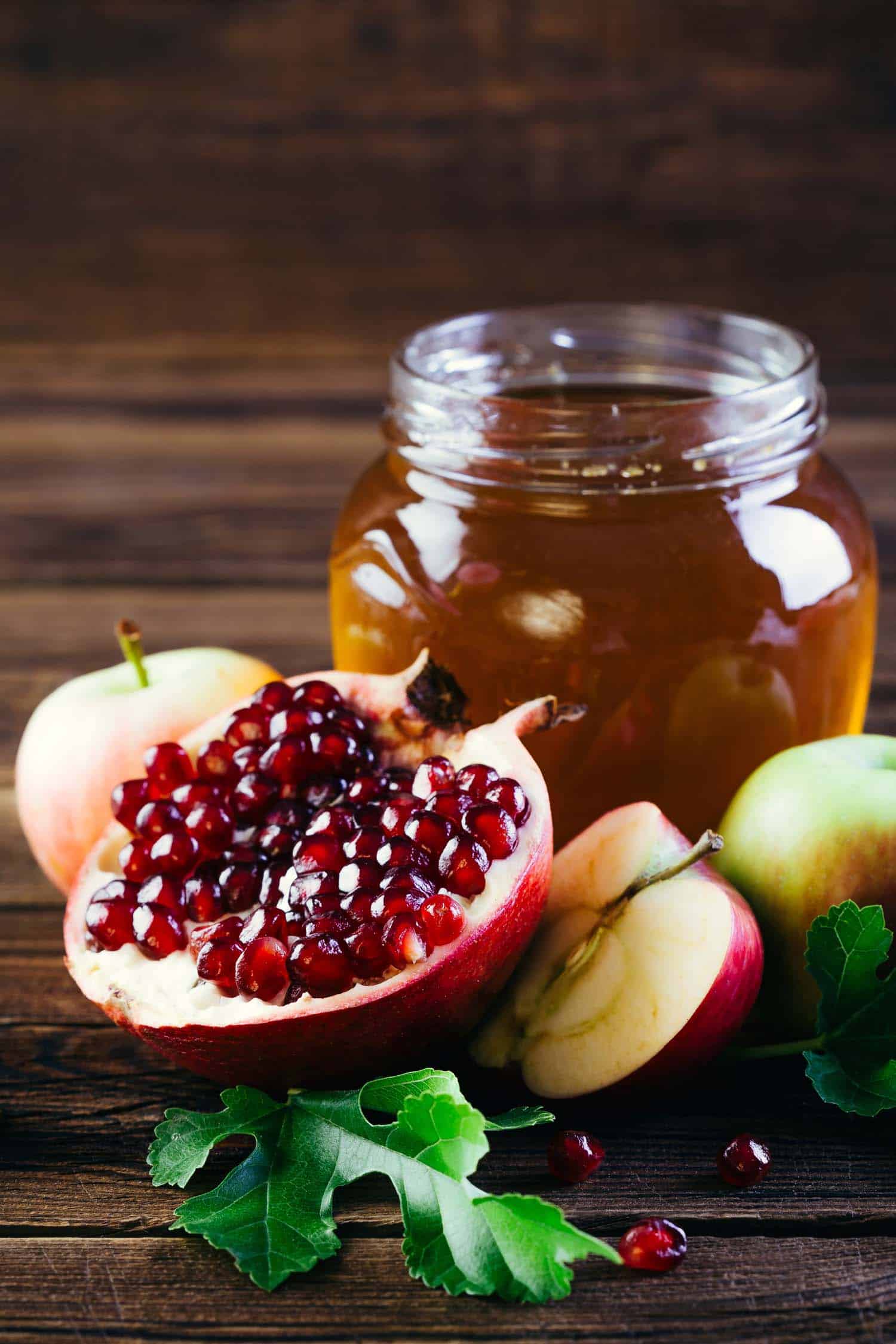 Rosh Hashanah table with honey, apple and pomegranate.