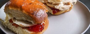 Elena Ruz sandwich, Cuban roasted turkey breast sandwich with strawberry jam, cream cheese on a grey plate and black background.