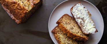 Homemade banana bread sliced on a dark background