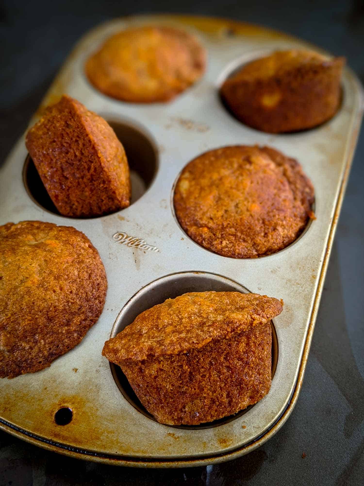 Pineapple carrot muffins in a muffin tin.