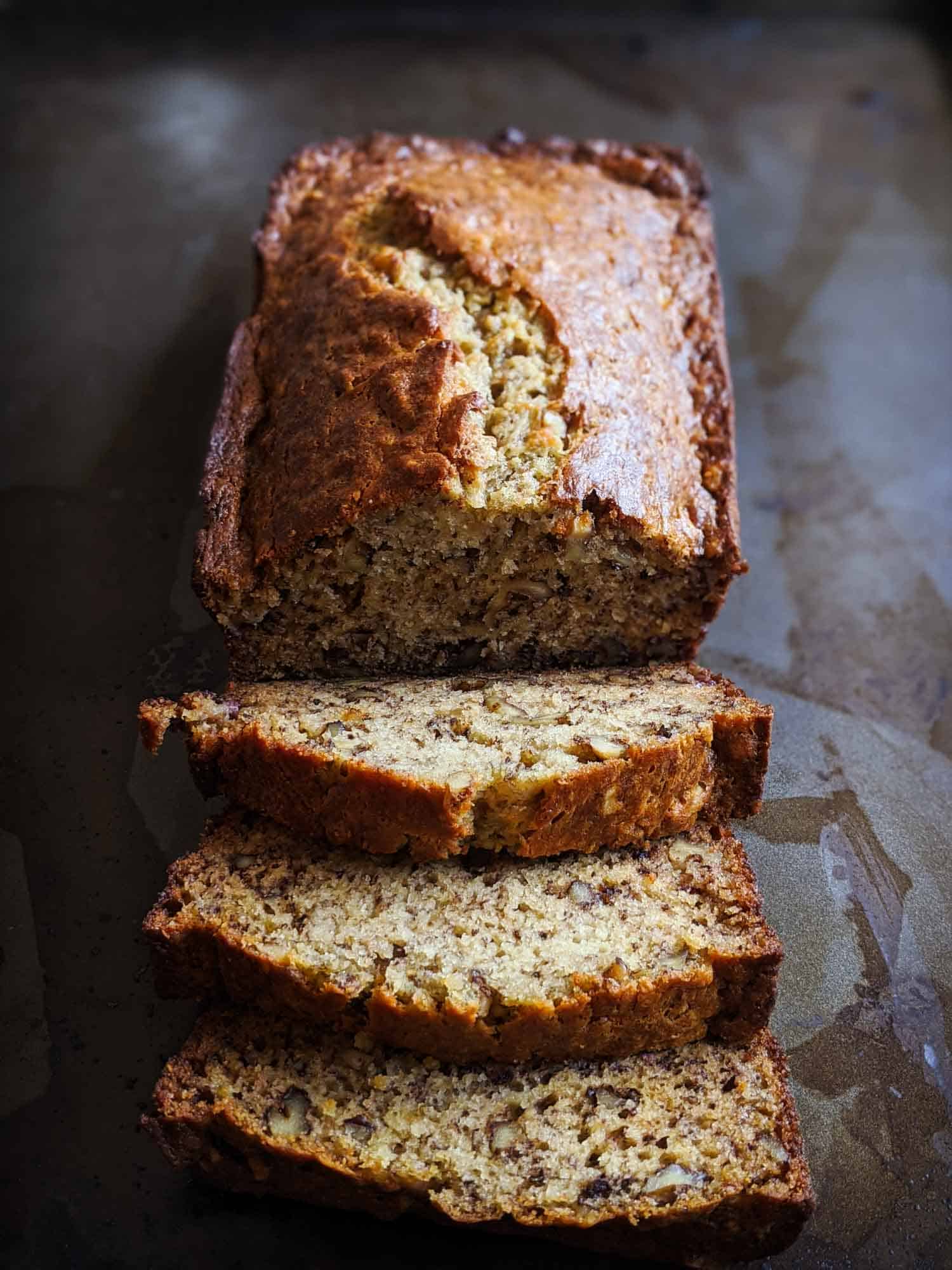 Homemade banana bread sliced on a dark background