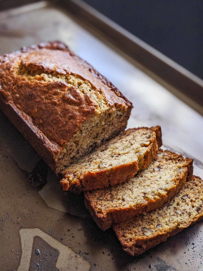 Homemade banana bread sliced on a dark background