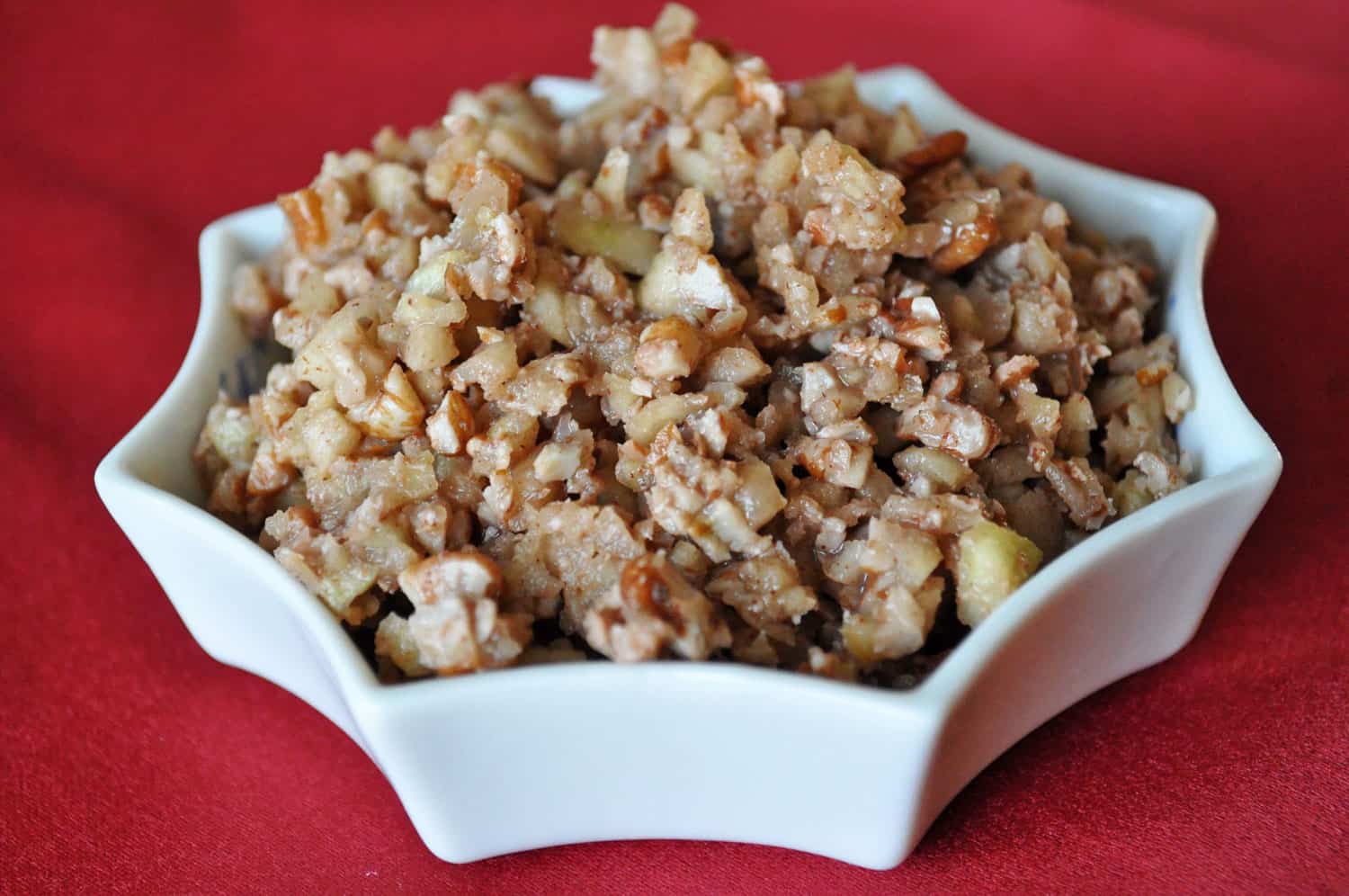 Passover food charoset in a white bowl on a red background.