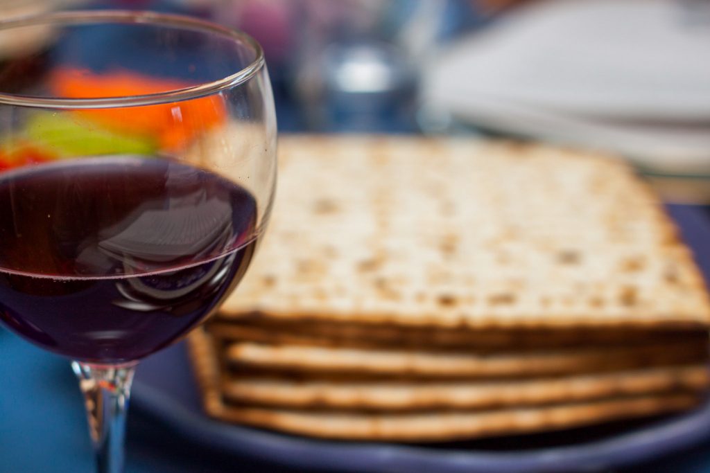 Passover seder wine with matzoh crackers in the background.
