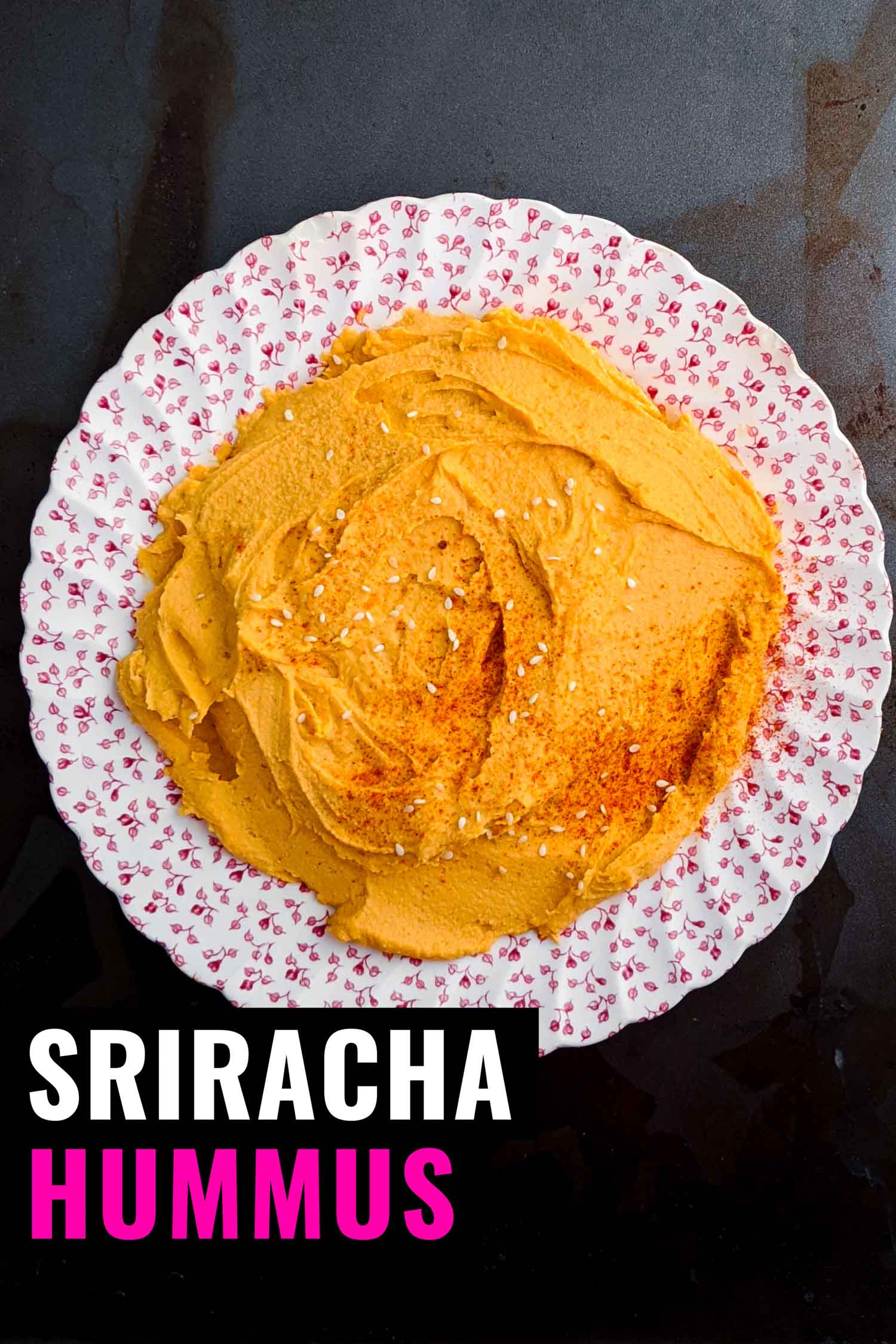 Sriracha hummus on vintage plate and dark background.