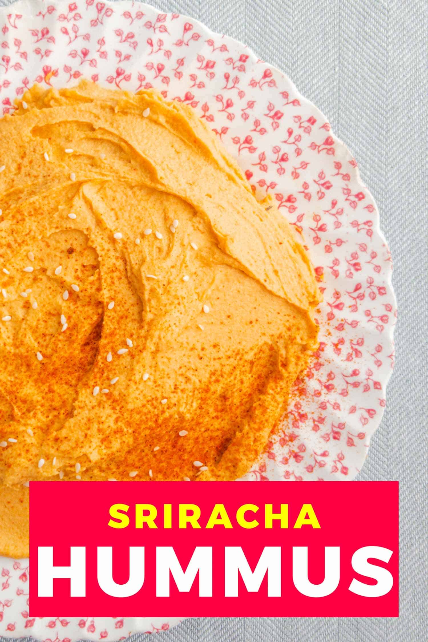 Sriracha hummus on a vintage pink flowered plate and grey background.