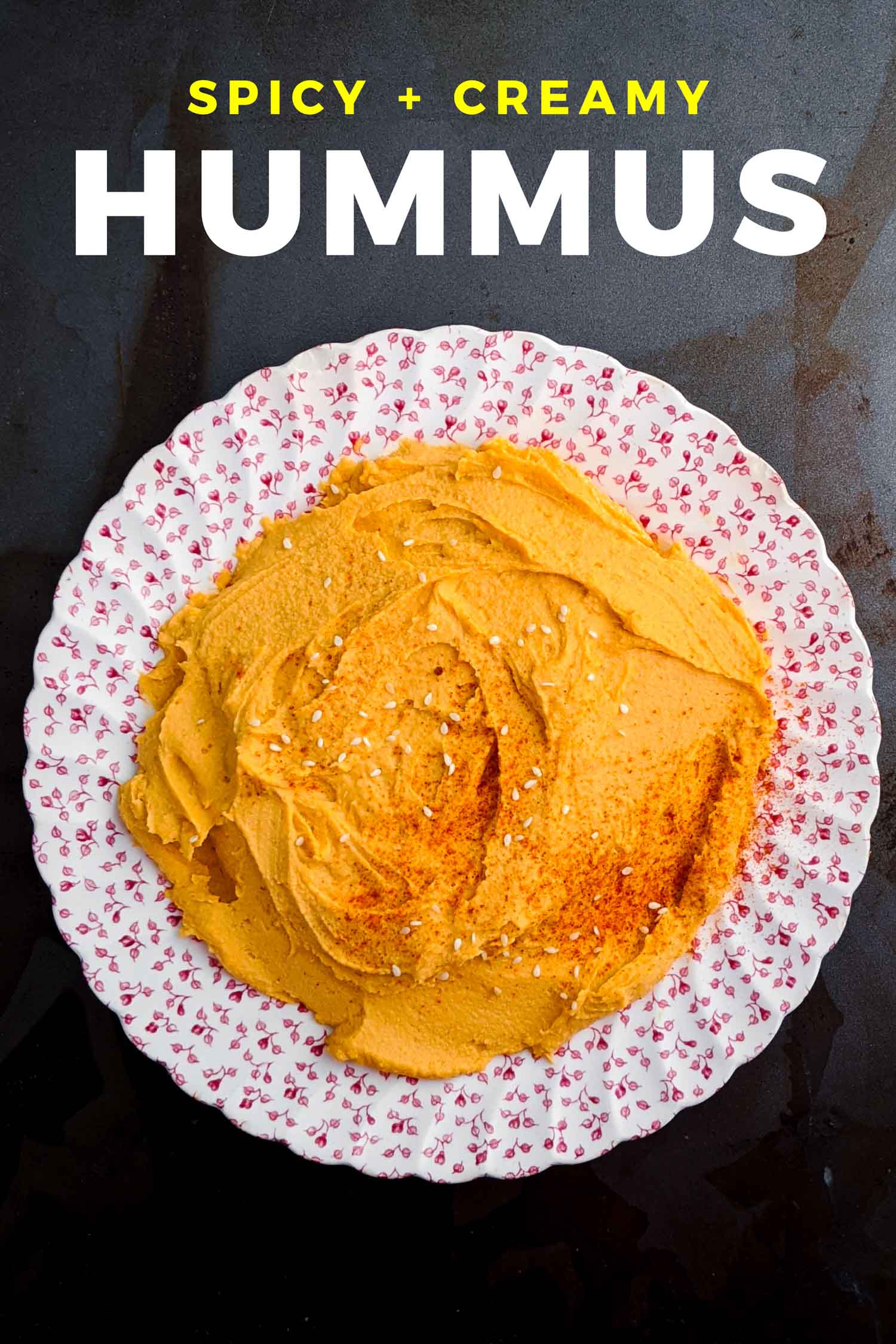 Spicy hummus on a vintage plate on a dark background.