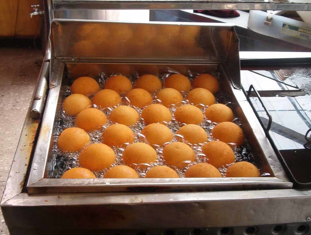 Bunuelos in Honduras lined up in a commercial fryer