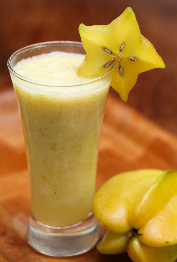 Carambola or starfruit juice in a glass with ripe fruit known as licuado juice in Honduras