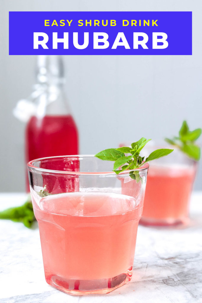 Basil rhubarb shrub in bottle next to two cocktails using it, garnished with basil.