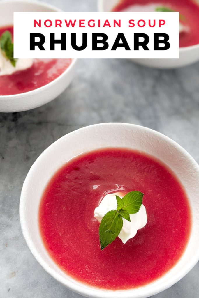 Cold rhubarb soup topped with whipped cream and mint in three white bowls on a grey marble background. with the words norwegian soup rhubarb