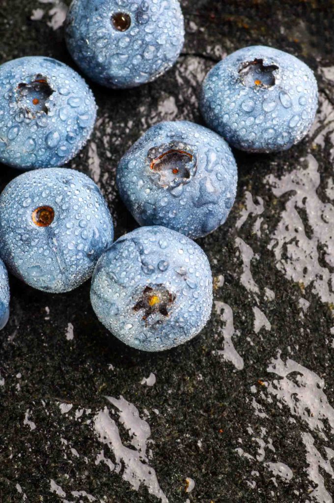 wet blueberries on black stone