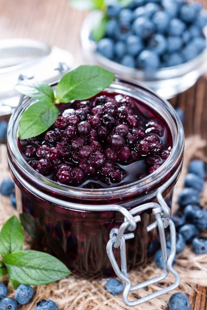 Glass with canned Blueberries and some fresh fruits