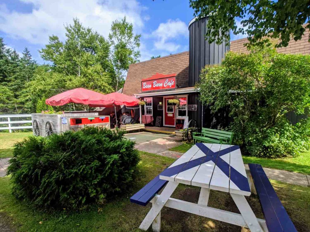 Cape Breton Ingonish bean Barn Cafe exterior with picnic table in front painted with Scottish flag