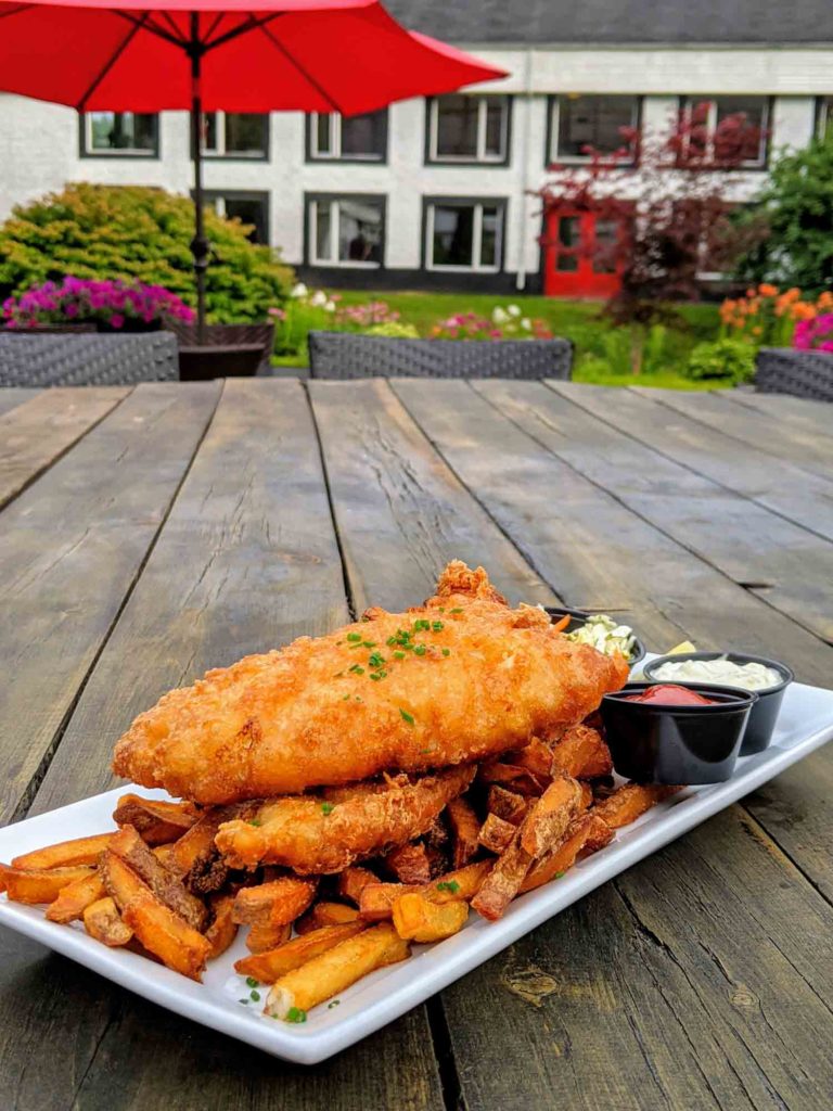 Glenora Inn and Distillery fish and chips on a wooden table, considered one of the best Cape Breton restaurants