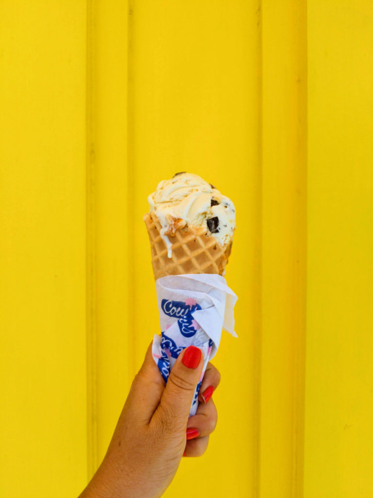 Hand holding cows ice cream on yellow background