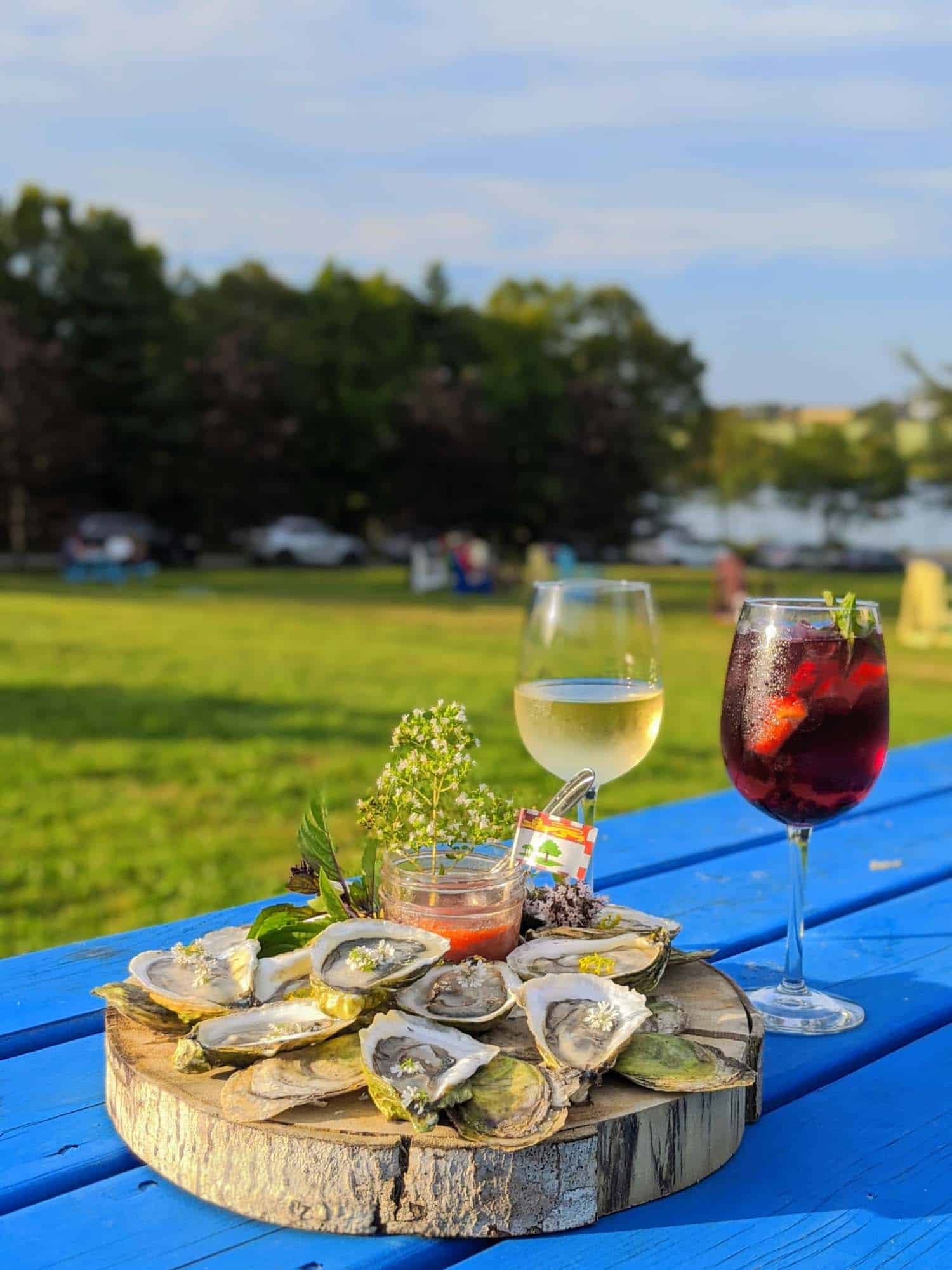 Oysters on a wooden trunk on a blue table with white wine and sangria