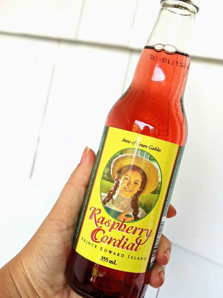Hand holding Anne of Green Gables raspberry cordial.