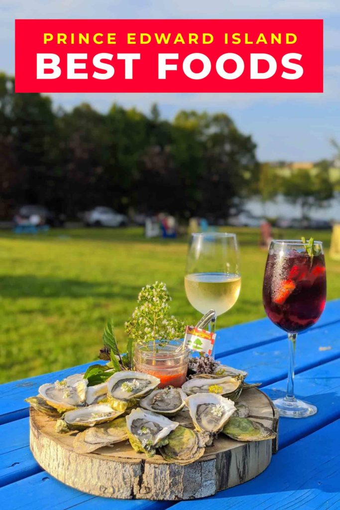 oysters on a blue picnic table with a glass of wine and a glass of sangria