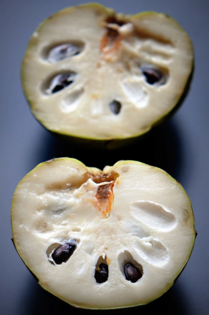 Custard apple cut open on black background