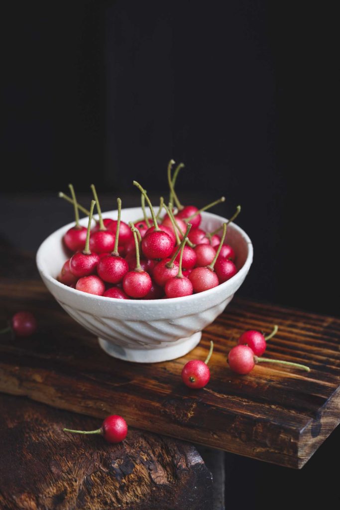 Panama cherry also called Jamaican cherry in a white bowl on a dark background