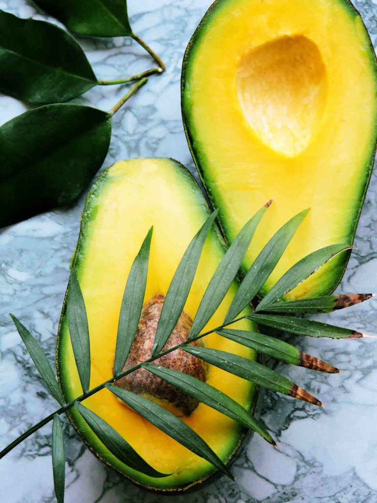 Fresh organic avocado isolated on white background.sliced avocado isolated. Tropical abstract background with avocado. Food concept. flat lay, top view.