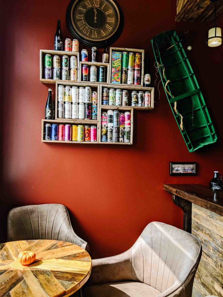 Tusket Falls Brewery interior, with cans on the wall and a table and chairs