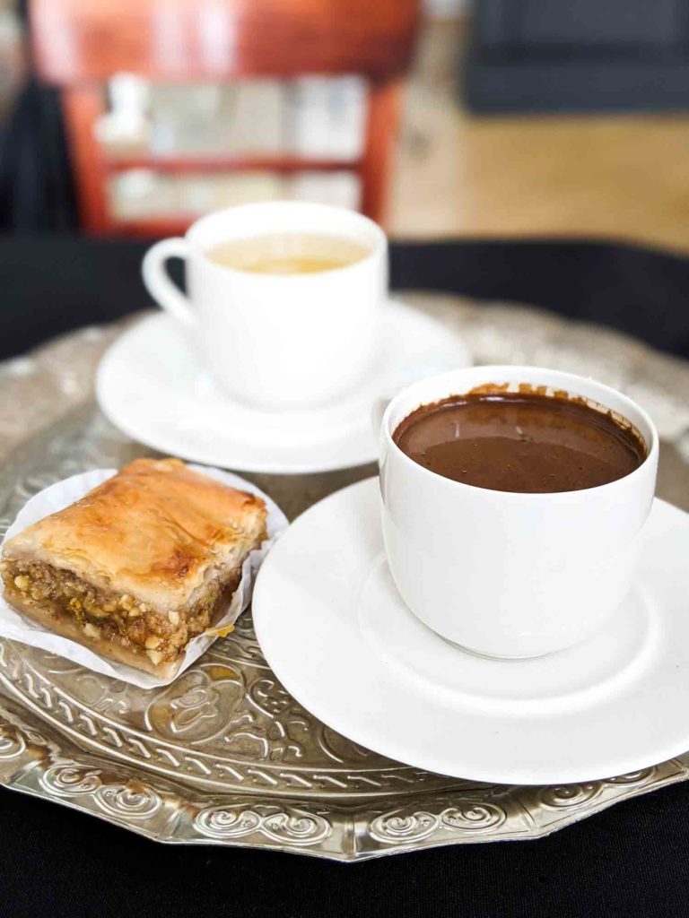 Arabic coffee, pumpking baklava and lemon ginger tea on a plate.