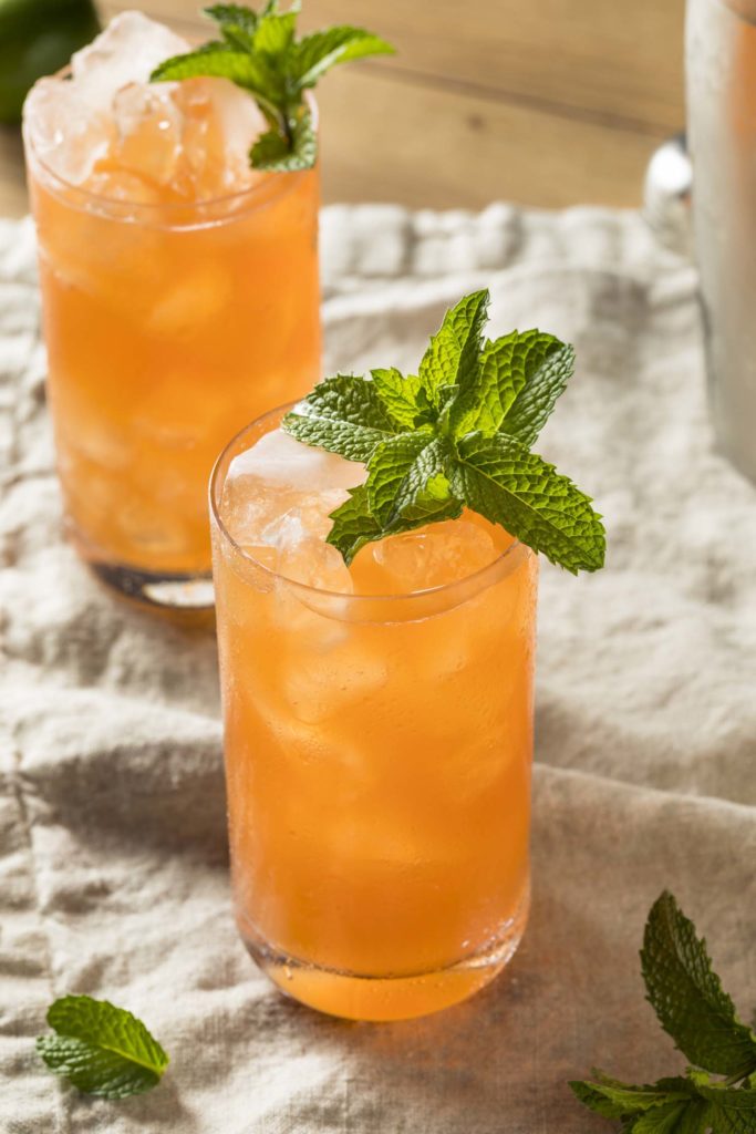 Two Zombie cocktails garnished with mint on rustic surface