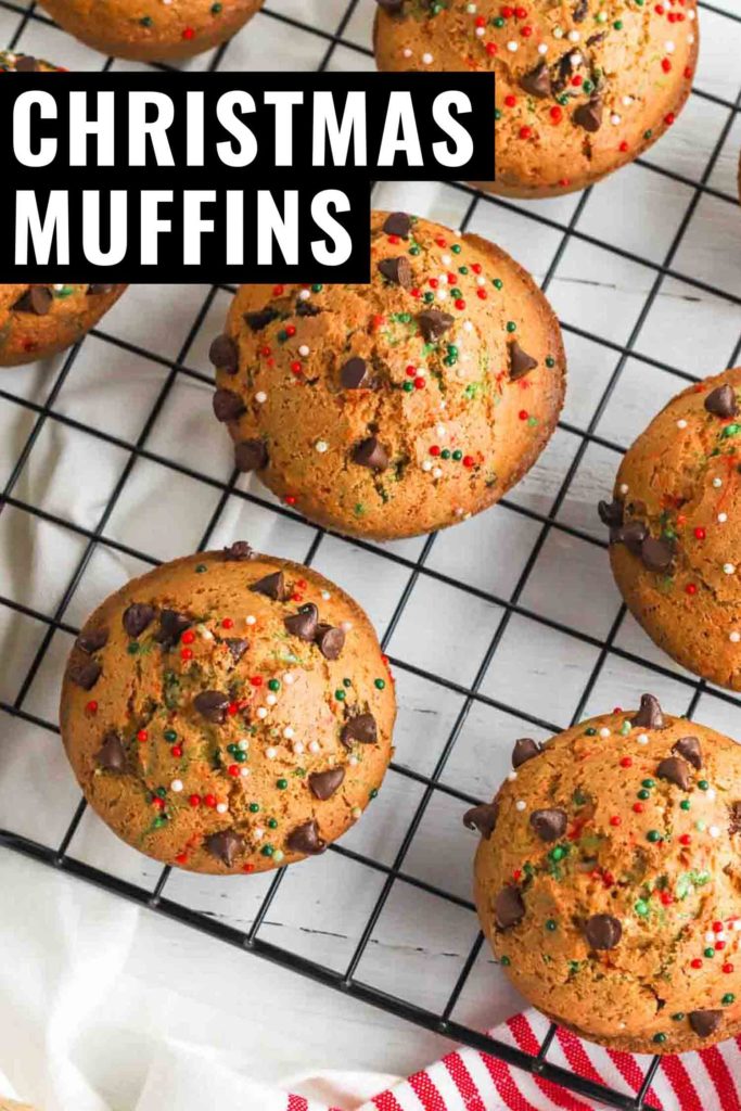 Holiday muffins with sprinkles on a cooling rack with whisk and red and white tea towel.