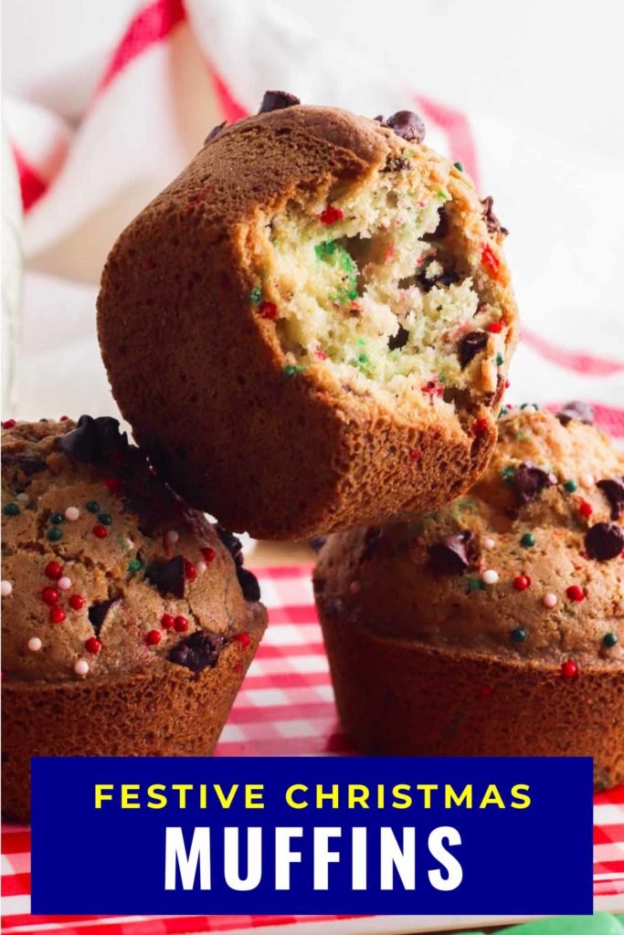 Christmas muffins stacked on red and white tablecloth with a bite out of one.