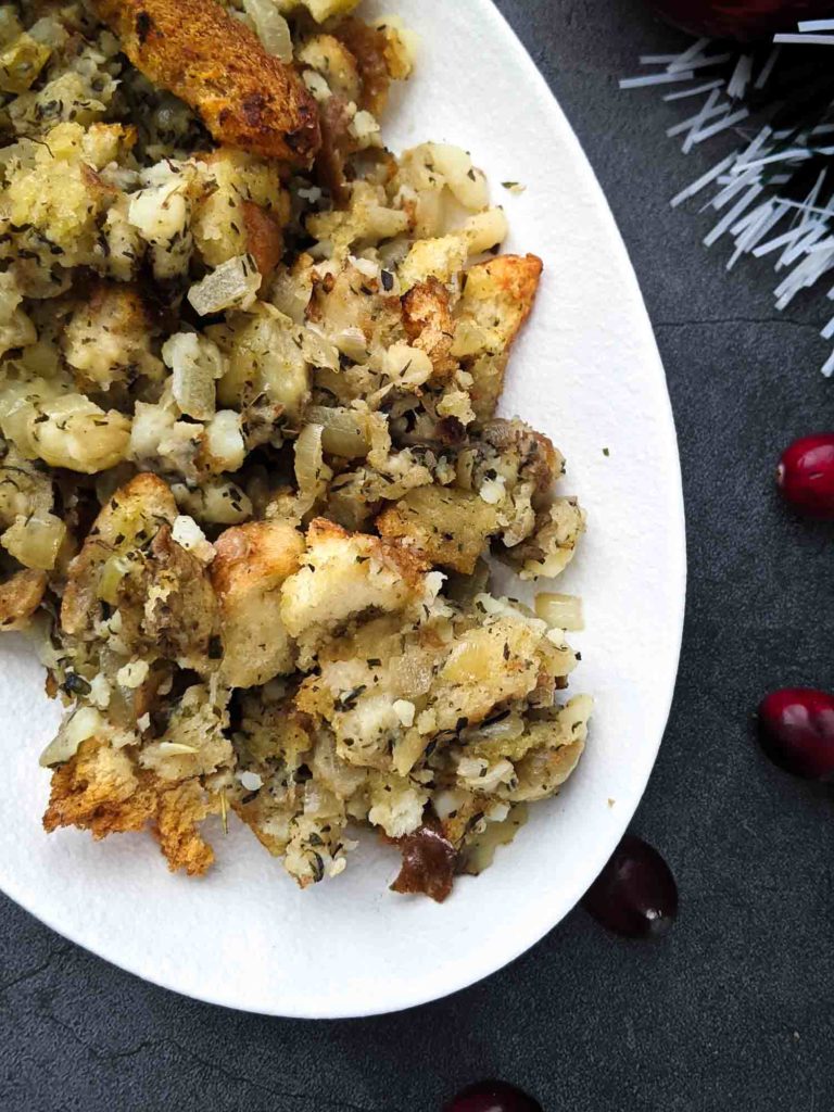 Turkey dressing with bread and potato on white plate grey background with Christmas ornaments