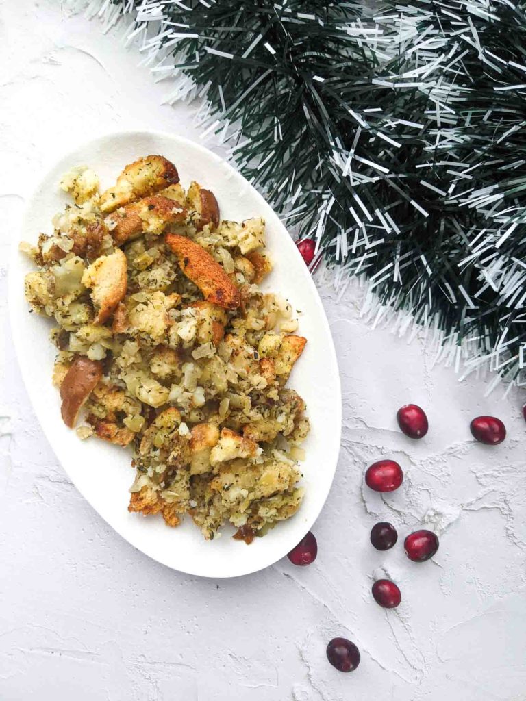 Turkey dressing with bread and potato on white plate and background with Christmas ornaments