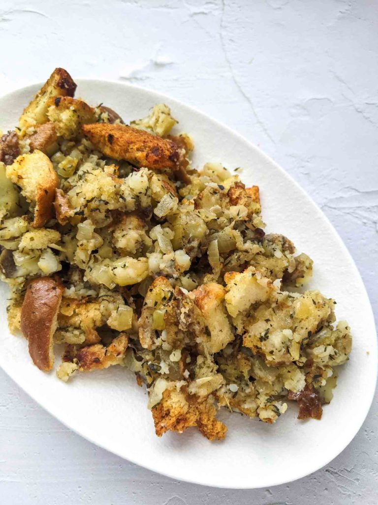 Turkey dressing with bread and potato on white plate and background