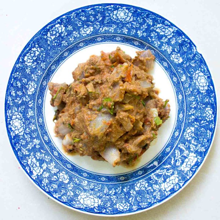 Sikil pak, a Mayan pumpkin seed dip on a blue plate and white background.
