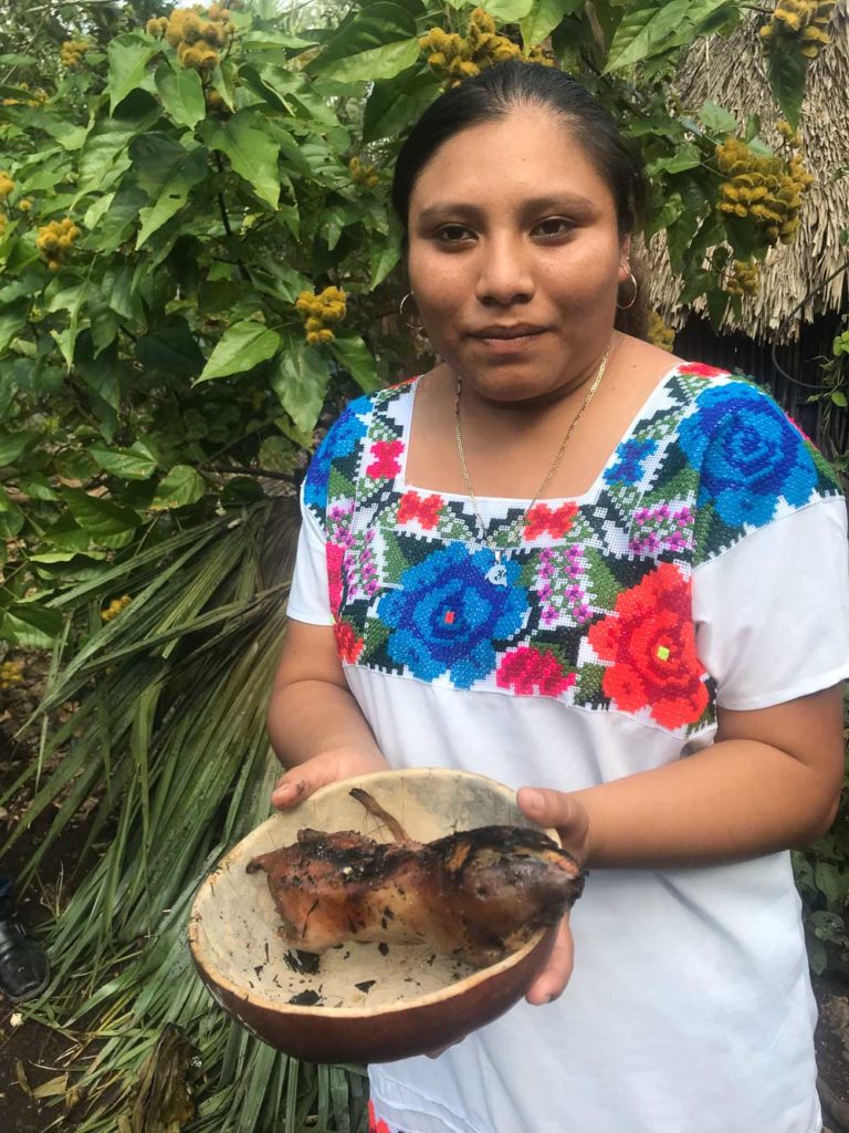 Young Mayan woman sharing tuza