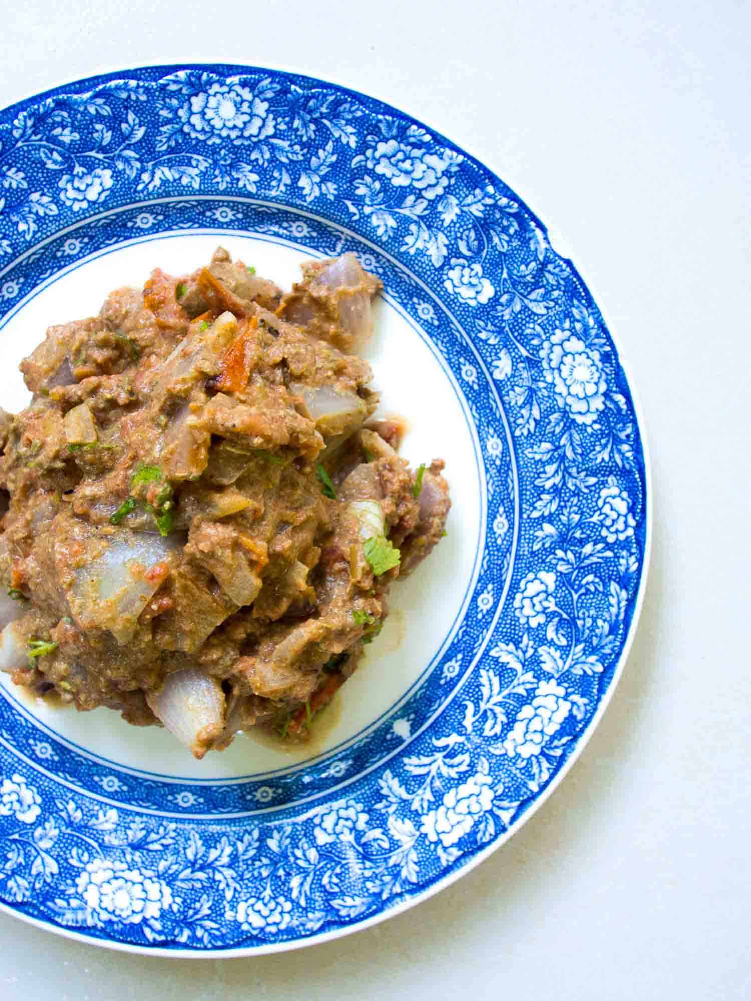 Sikil pak, a Mayan pumpkin seed dip on a blue plate and white background.