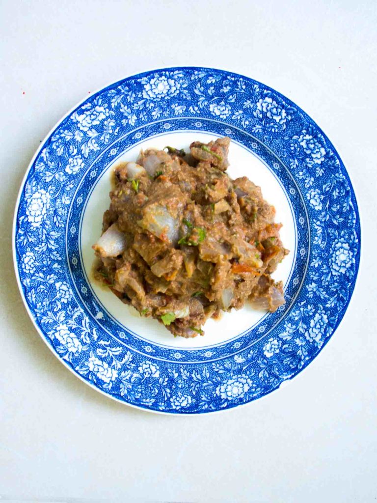 Sikil pak, a Mayan pumpkin seed dip on a blue plate and white background.