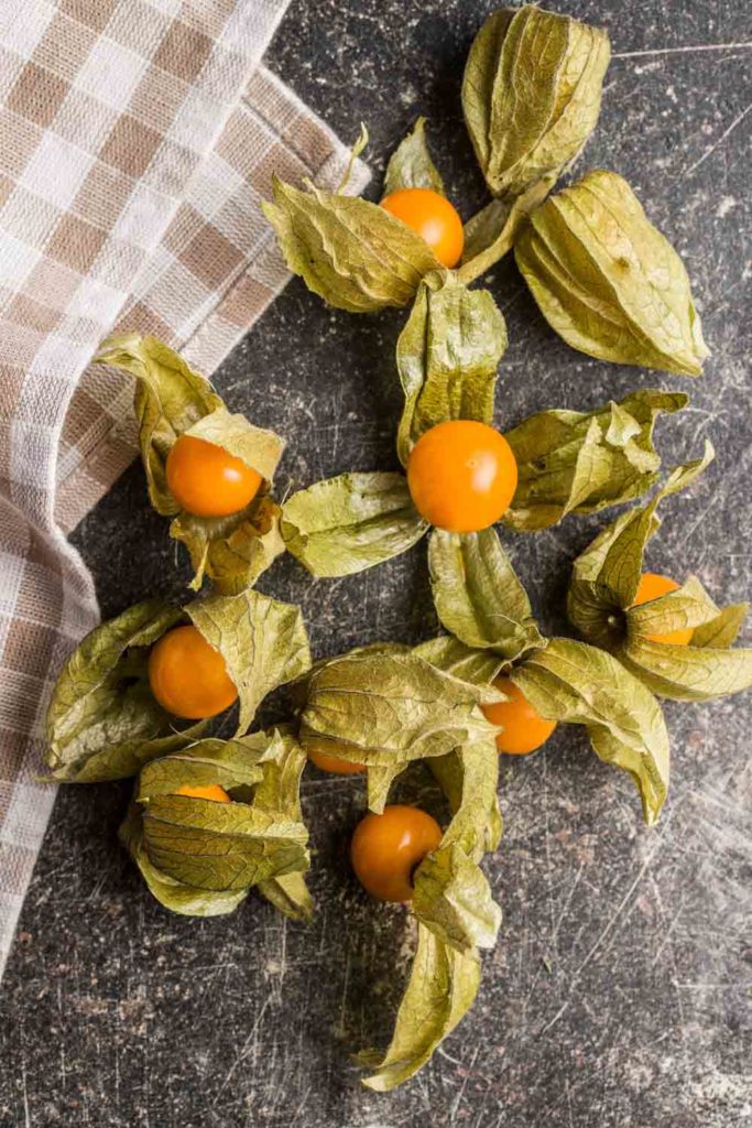 Physalis peruviana fruit on old kitchen table. Top view.