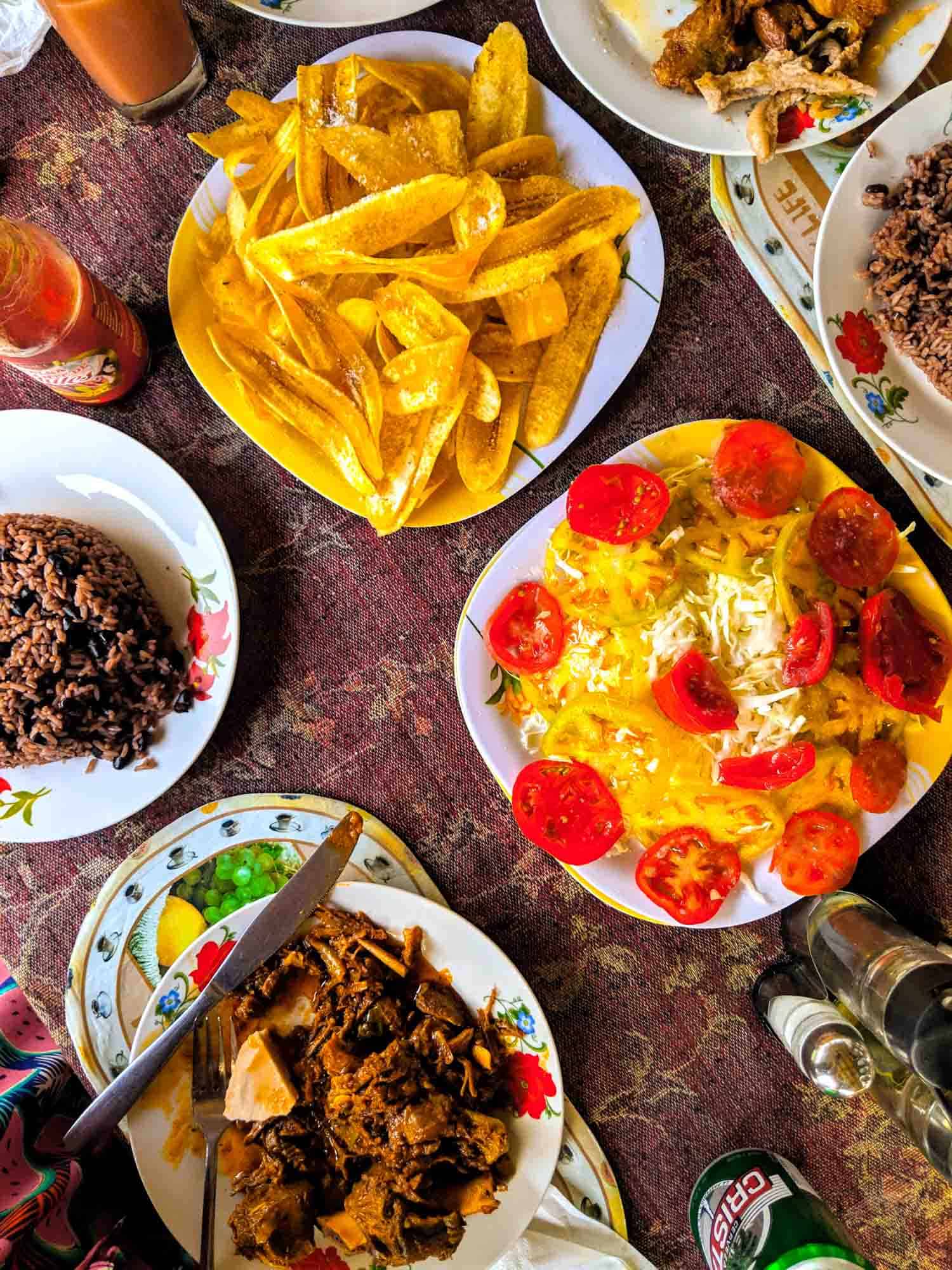 Typical countryside food at El Nicho, Cuba including plantains, cabbage, tomatoes, congri Cuban rice and stewed goat along with Cristal beer